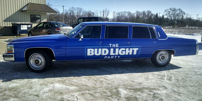 Full color change wrap and lettering on an older Cadillac Limousine for Bud Light